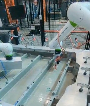 Laboratory setup with camera and filter lens on one cobot and gas excitation source on the other.