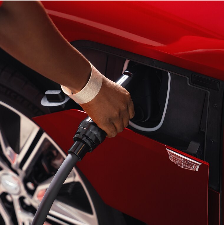 Someone inserting an EV Charger into a Charging Port of a GM Vehicle