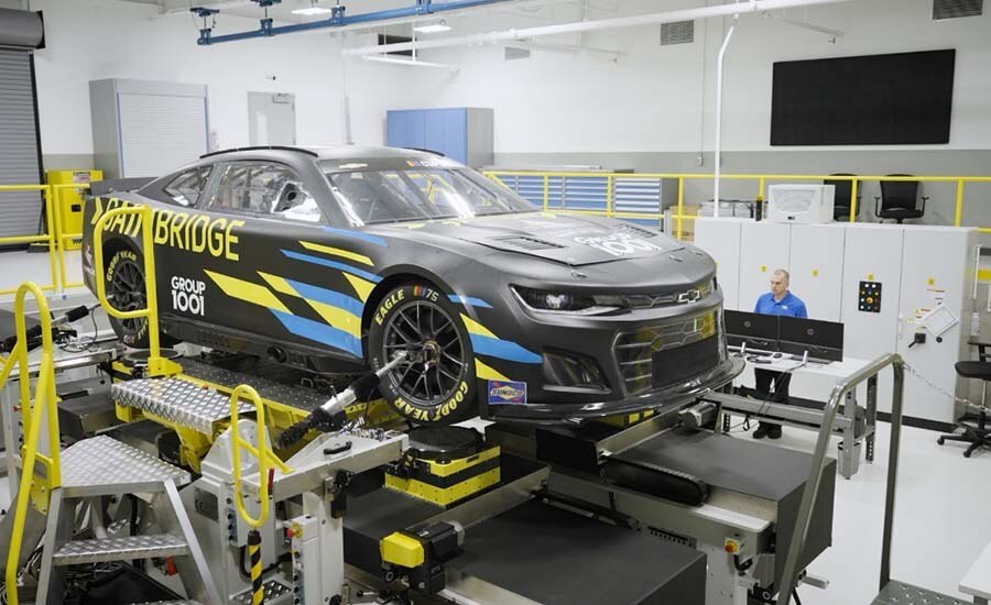 Three-quarters View of a Chevrolet Racecar Lifted in a GM Warehouse Being Worked On