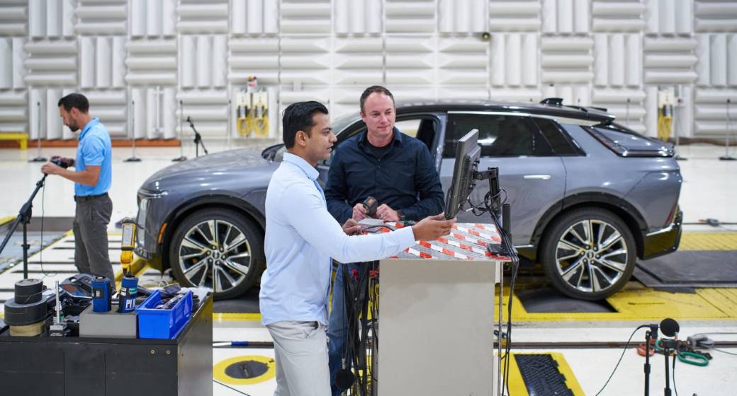 Two GM Team Members Working on New Software in Front of a Vehicle in a Warehouse