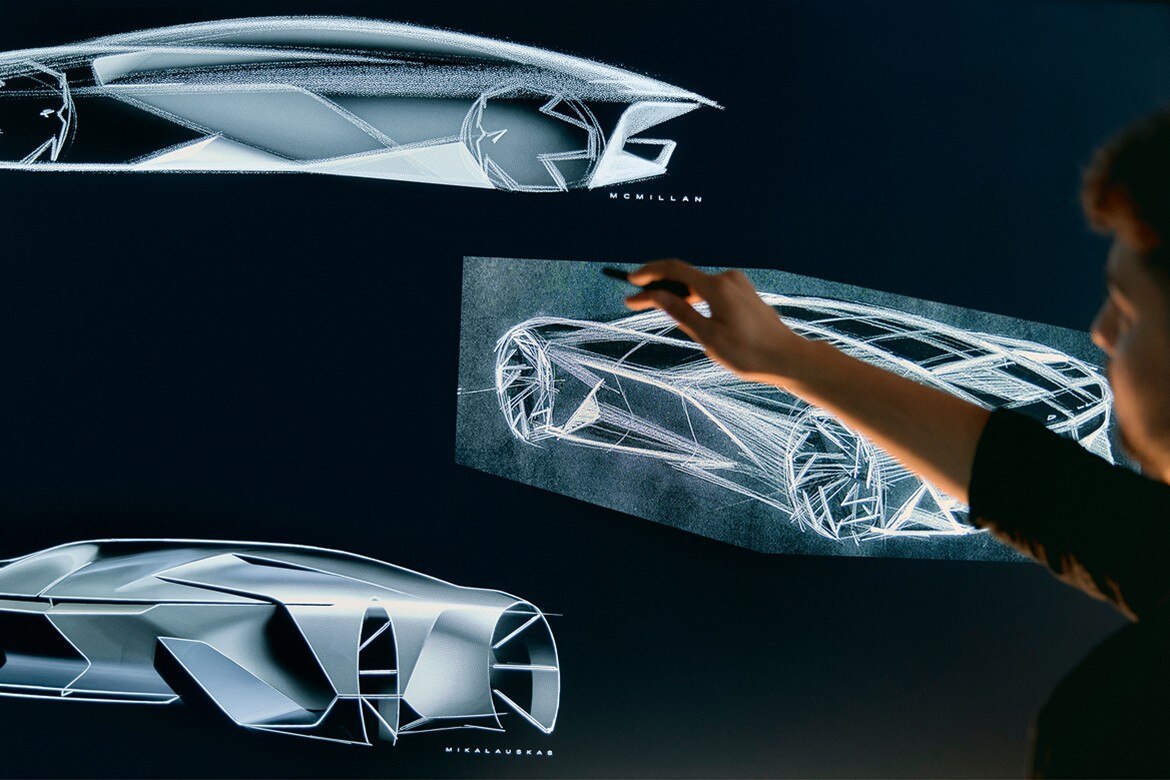 Close-up of a Man Pointing on a Drawing Board Displaying GM’s Concept Vehicle Designs 