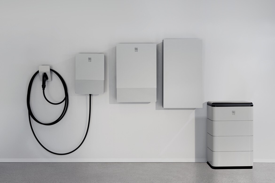 White modern garage interior with GM Energy wall-mounted energy management unit for home energy storage and EV charging.