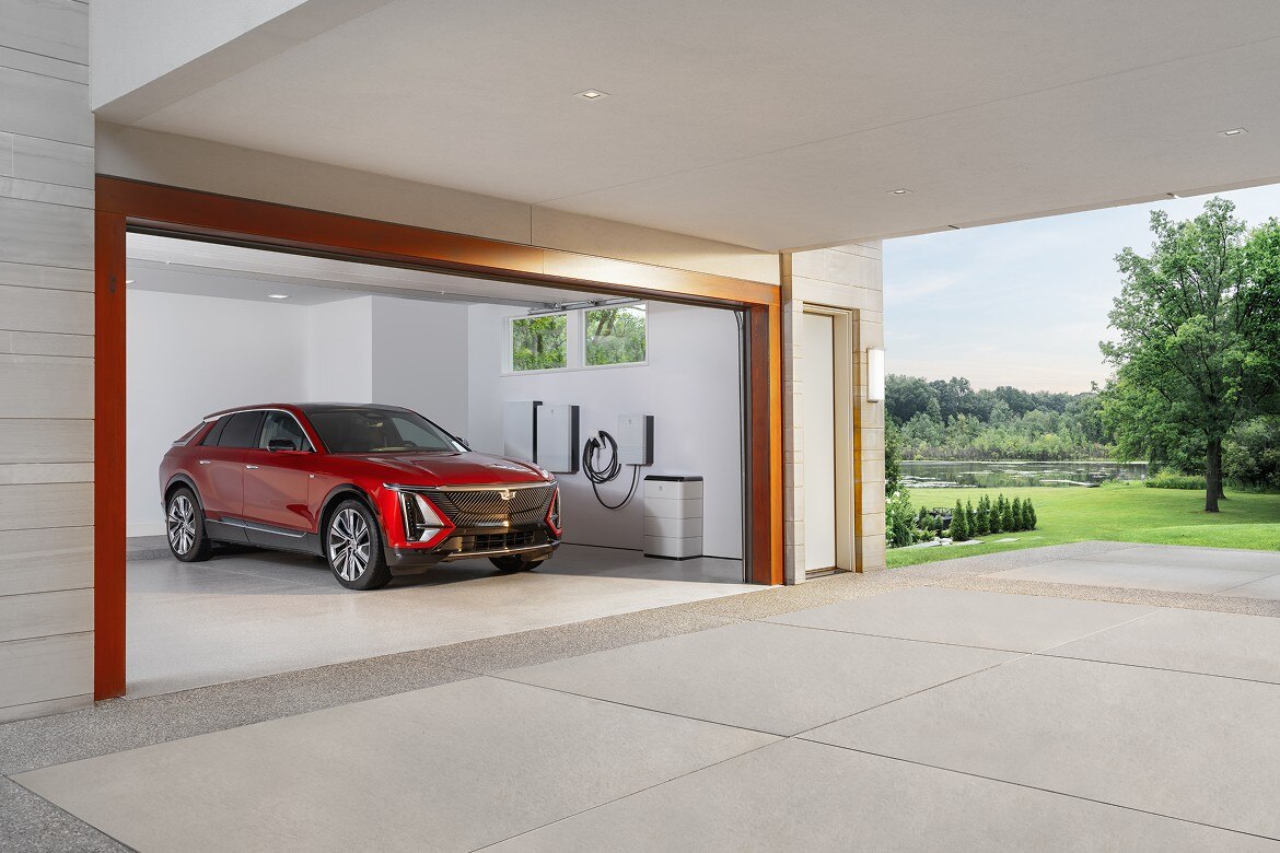 Red Cadillac Lyriq EV charging in modern residential garage with wall-mounted EV power system.